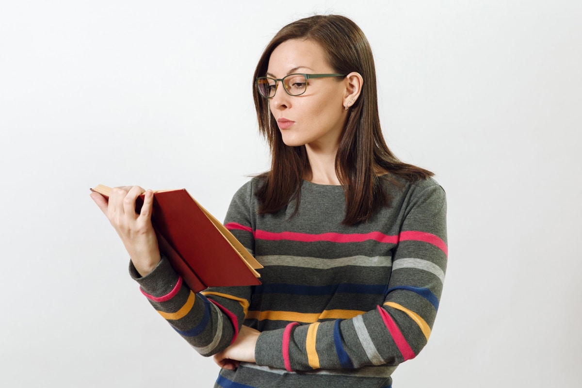mujer con lentes lee libro
