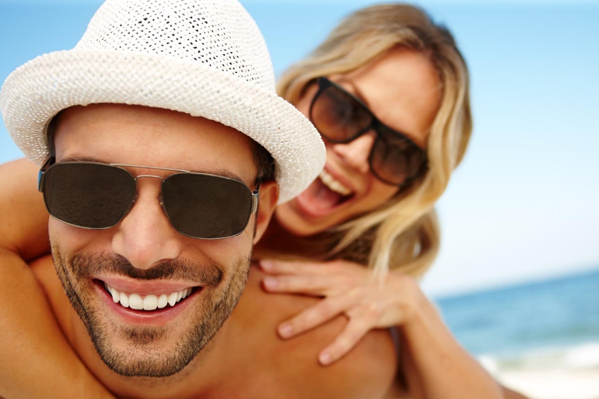 pareja feliz con lentes en playa